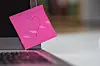 laptop med en rosa postit-lapp påtegnet et hjerte
